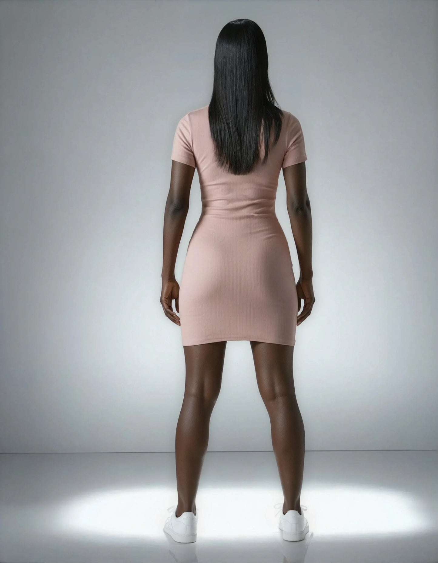 Femme de dos portant une robe courte côtelée rose, tendance 974 Réunion