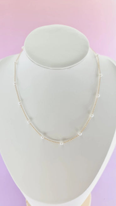 Collier fin doré avec perles blanches, bijou femme tendance 974 Réunion, fond rose violet