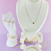 Bijoux dorés femme 974 Réunion, collier, bracelets, boucles d’oreilles sur fond rose