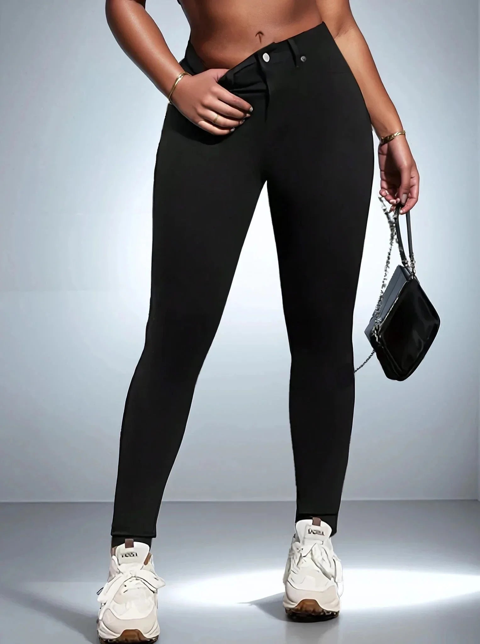 Femme portant un jean skinny noir, baskets blanches, sac à main, 974 Réunion mode