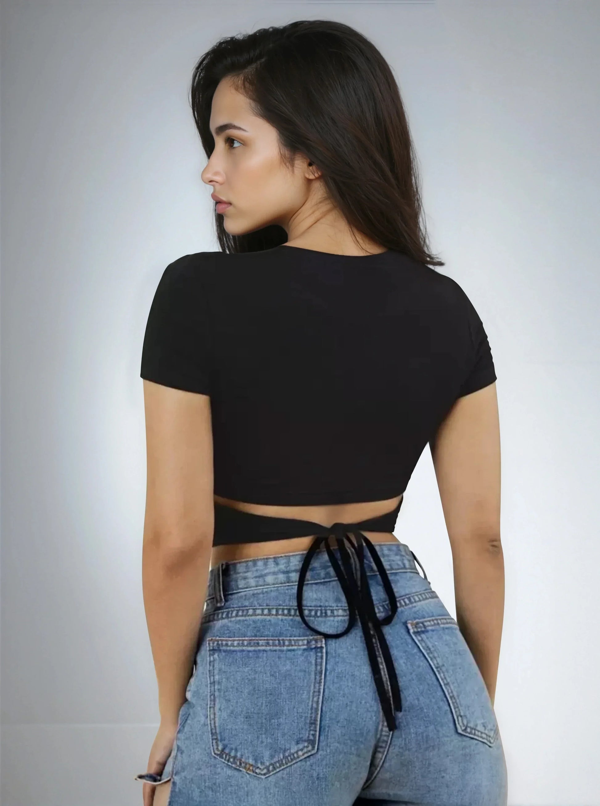 Femme de dos portant un crop top noir à nouer et un jean bleu, mode 974 Réunion